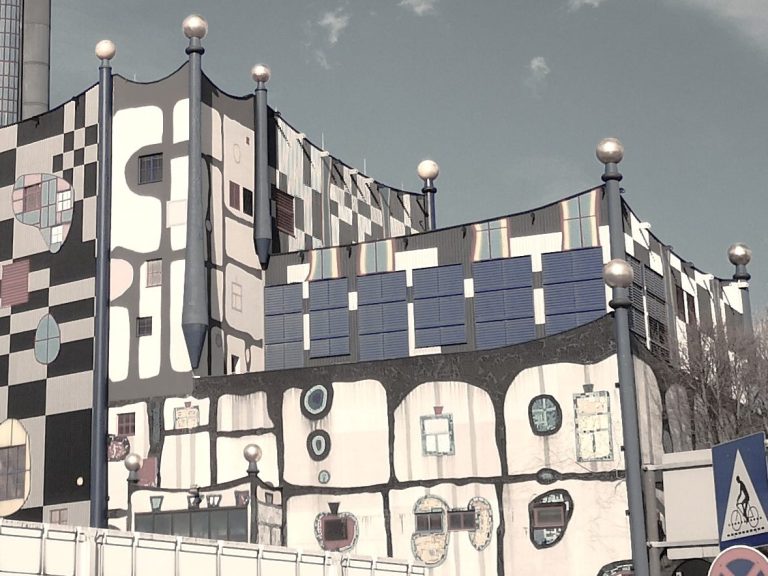 Fassade eines bunten Gebäudes mit geometrischen Mustern und dekorativen Elementen.